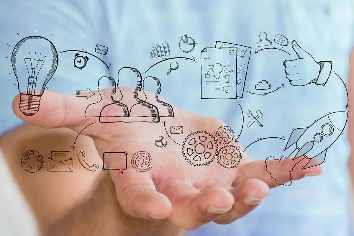 Bild: sdecoret / stock.adobe.com Eine Person hält eine Hand mit einer Zeichnung eines Geschäftssymbols, das Kreativität und Unternehmertum symbolisiert.